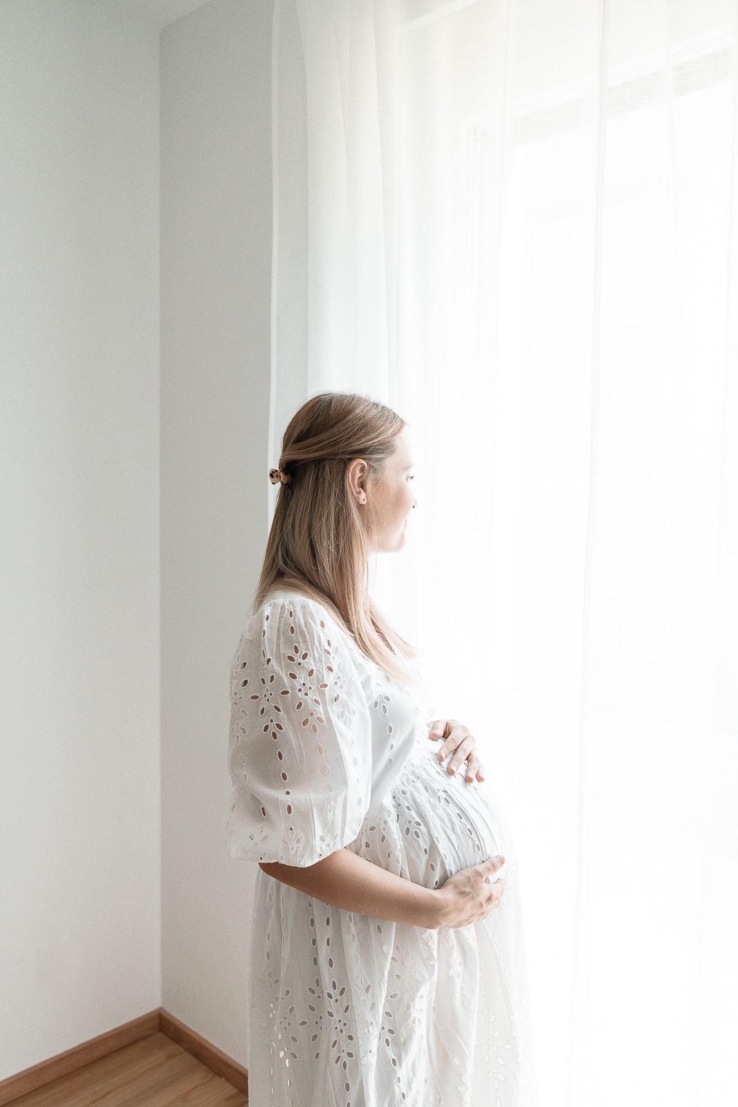 Babybauchfotografin Weiz, werdende Mama vor einem großen Fenster