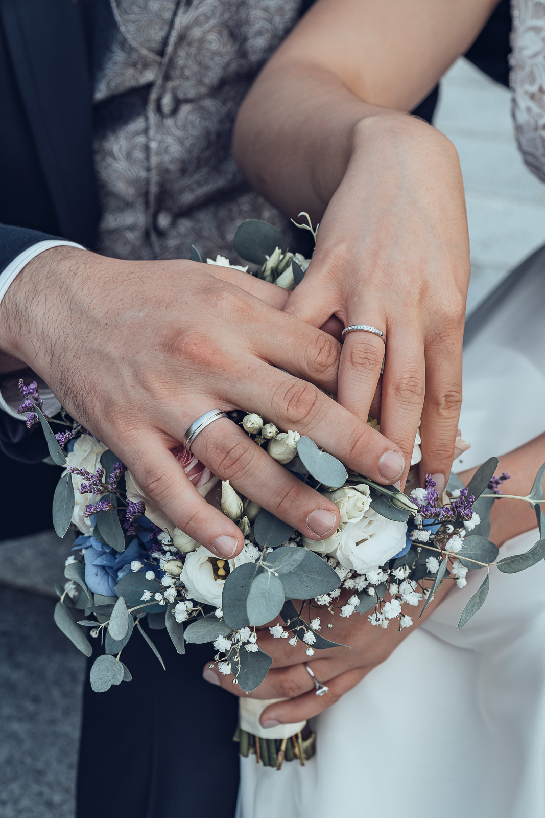 Hochzeitsfotografin Weiz, Hochzeitsstrauß mit den Händen des Brautpaares darauf