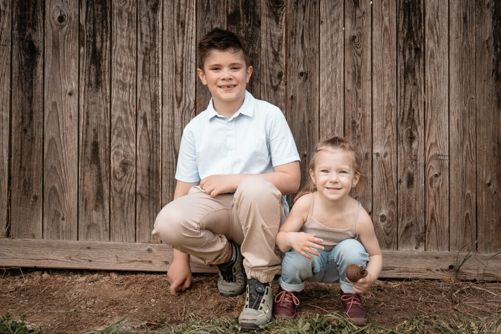 Familienfotografin Weiz, Gleisdorf und Hartberg, zwei Kinder Outdoor vor einer Scheune