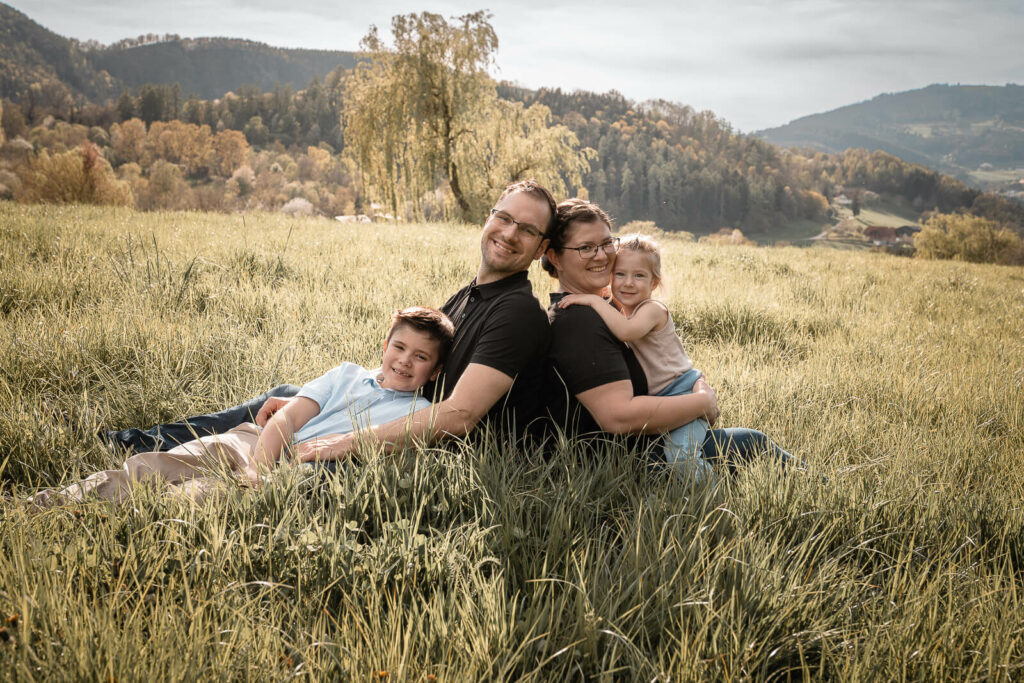 Familienfotografin Weiz, Gleisdorf und Hartberg, Familie mit zwei Kindern Outdoor sitzen im Gras