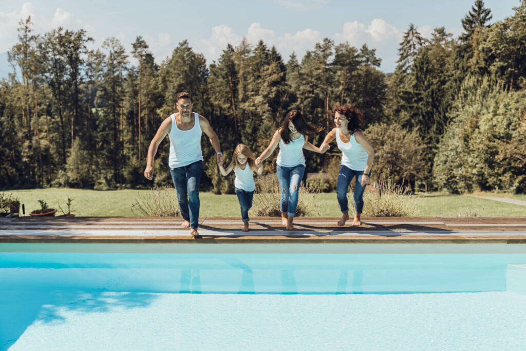 Familienfotografin Weiz, Gleisdorf und Hartberg, Familie springt mit Kleidung in den Pool