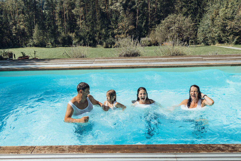 Familienfotografin Weiz, Gleisdorf und Hartberg, Familie mit Kleidung im Pool